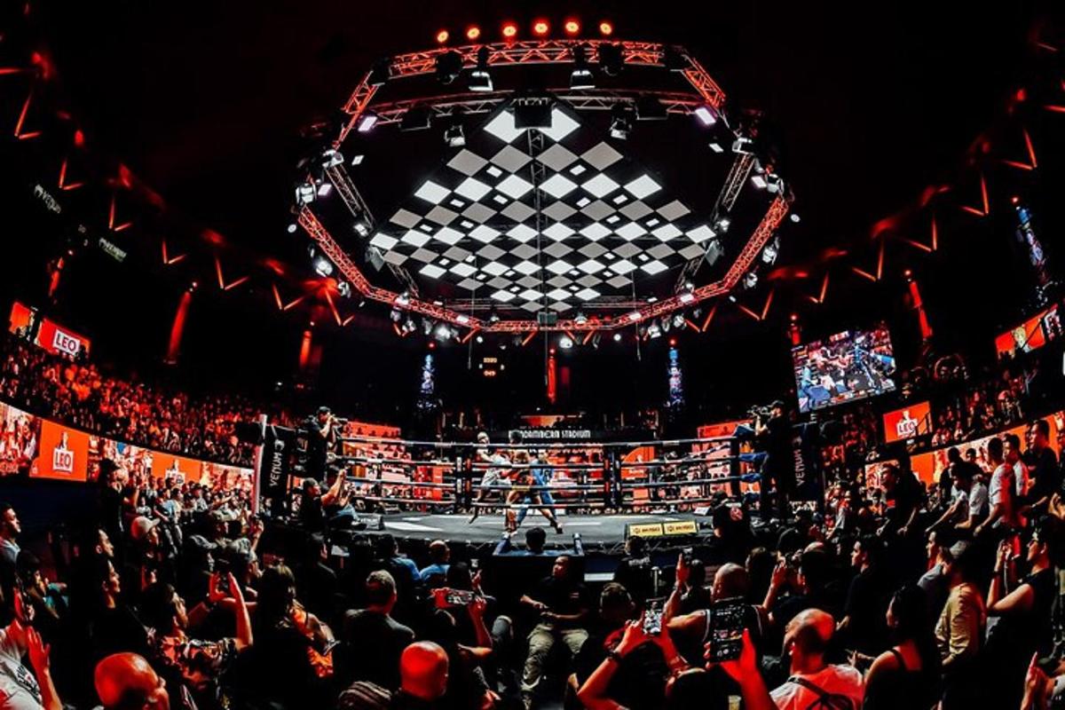 a crowd of people watching a boxing match in an arena