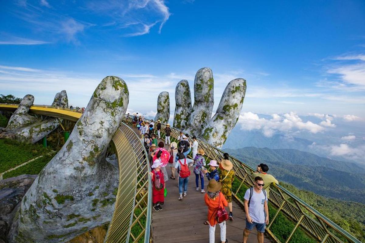 un gruppo di persone che camminano su un ponte sospeso con una mano gigante
