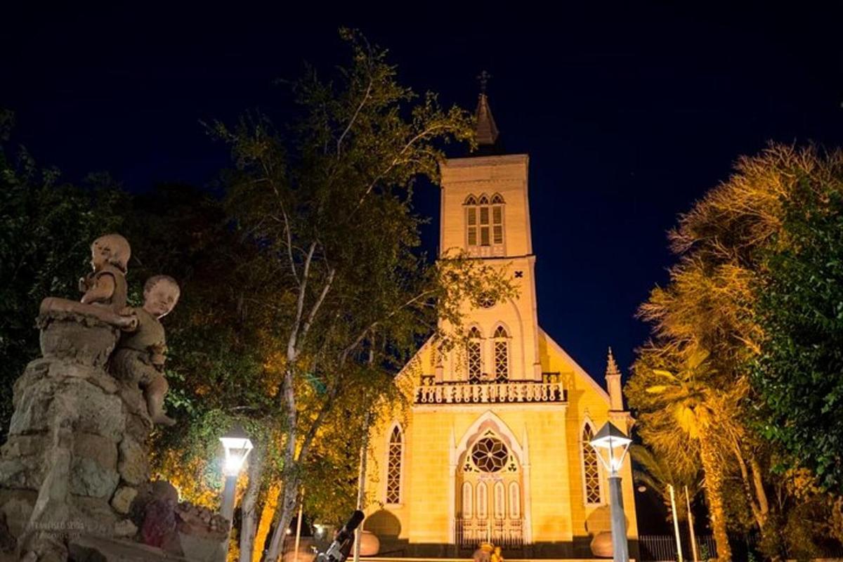 una chiesa con una torre dell'orologio di notte