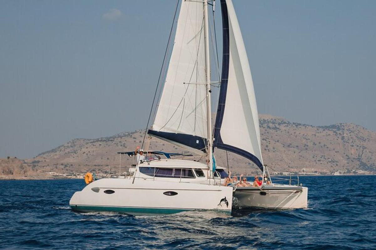 una barca a vela bianca in acqua con persone a bordo