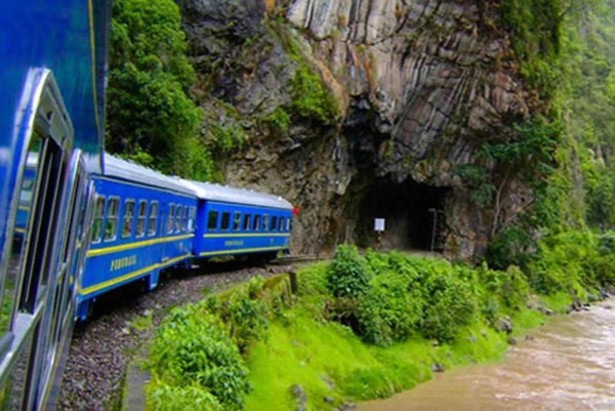 kereta api biru sedang melewati terowongan di pegunungan