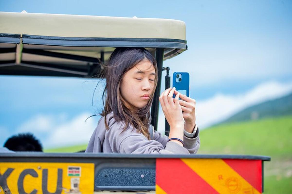 una donna seduta su un treno che guarda il suo cellulare