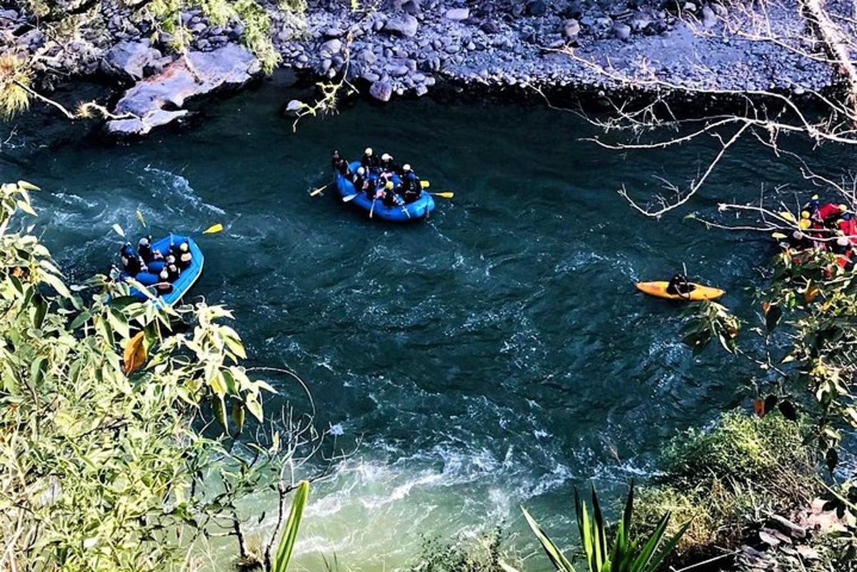 sekumpulan orang berakit menyusuri sungai dengan sampan