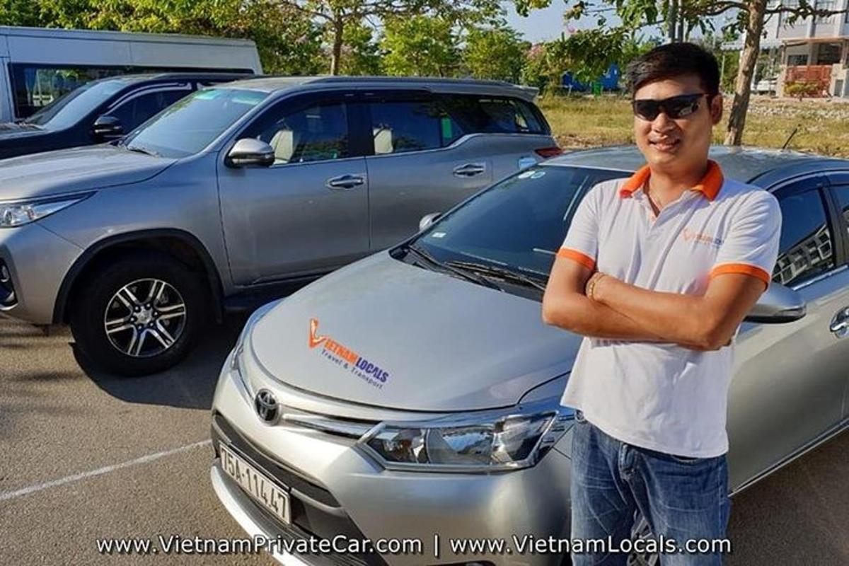 seorang lelaki berdiri di hadapan sebuah kereta berwarna perak