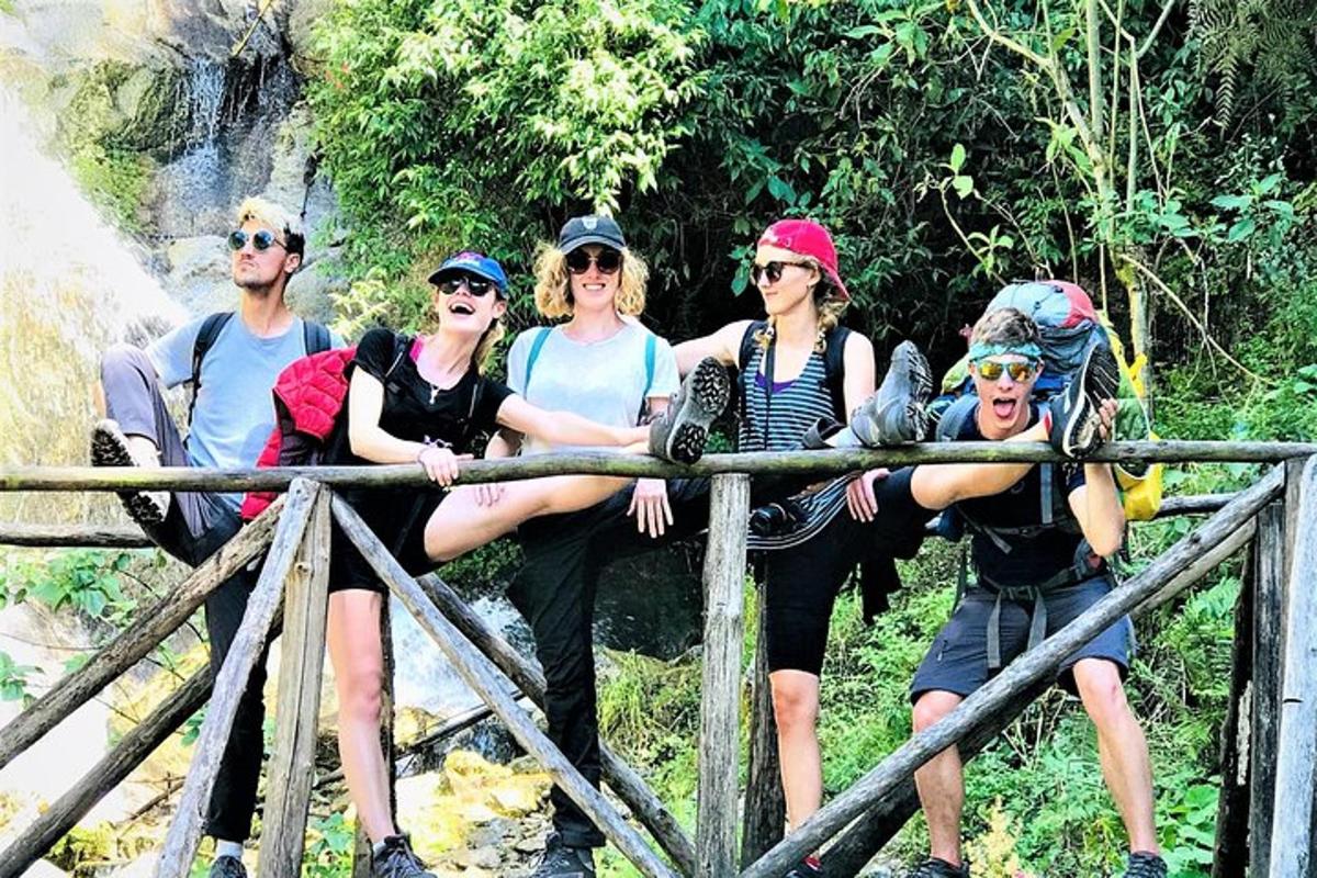 un gruppo di persone sedute su un ponte vicino a una cascata