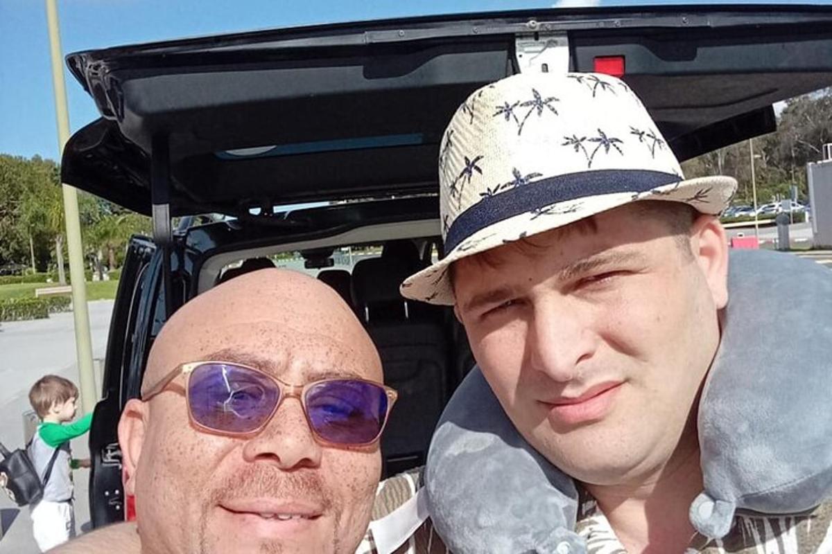 dva muži stojící před autem s kloboukem