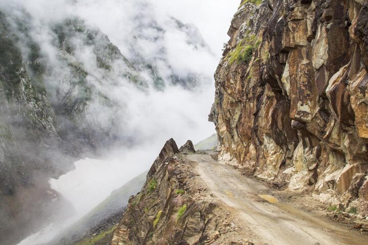 a dirt road up a mountain in the clouds