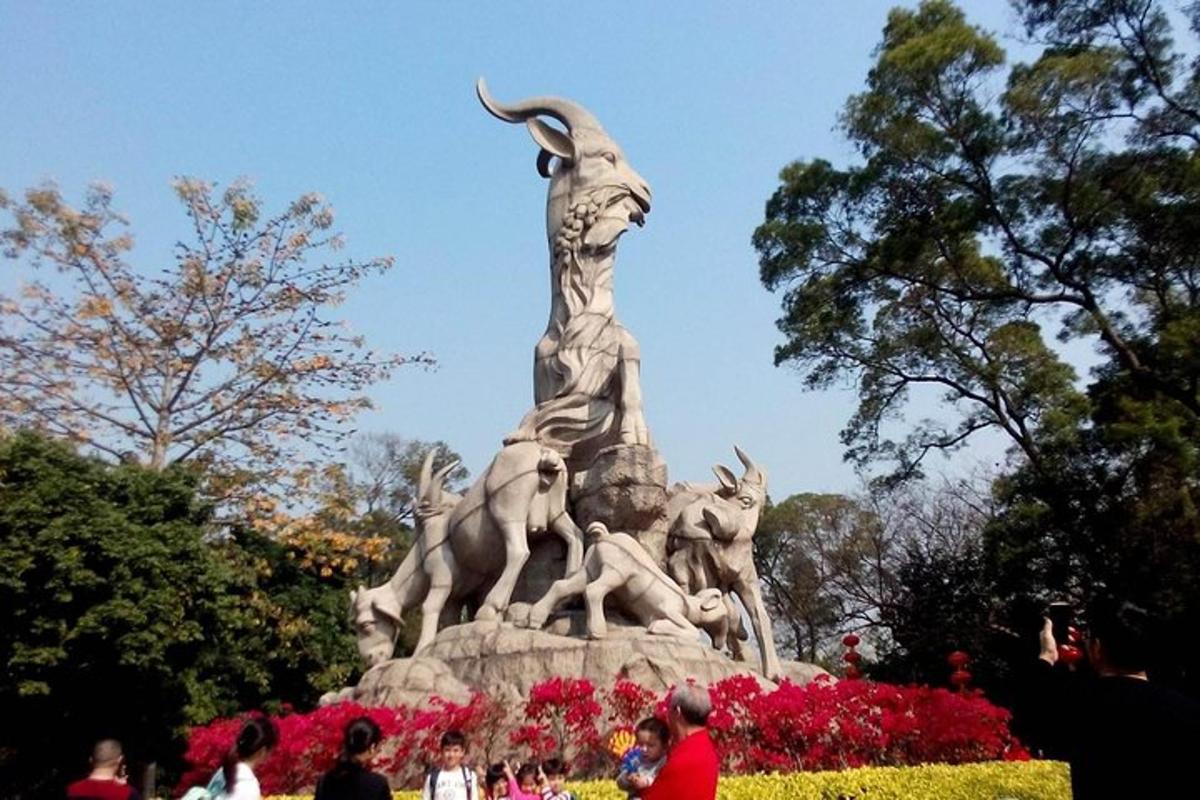 une statue dans un parc avec des gens debout autour d'elle