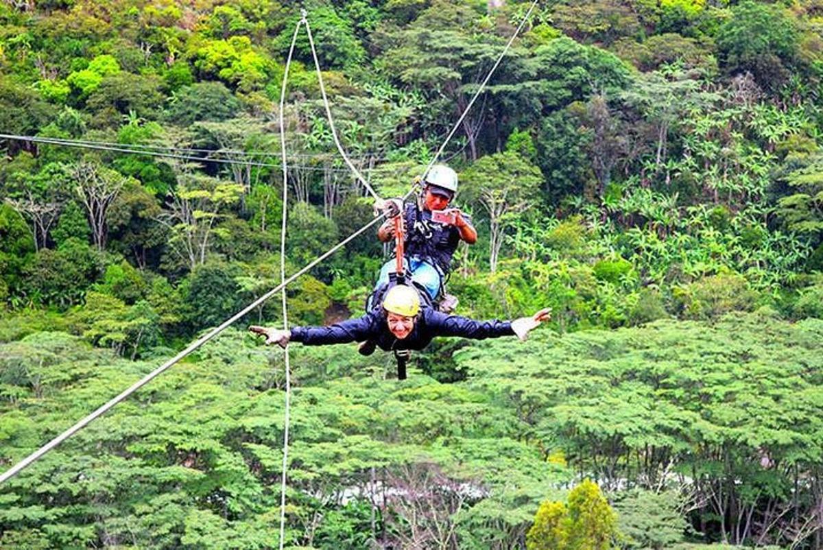 hai người trên đường trượt zipline trong rừng