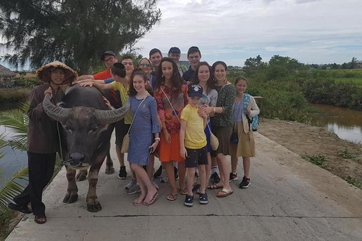 Un grupo de personas de pie junto a una vaca