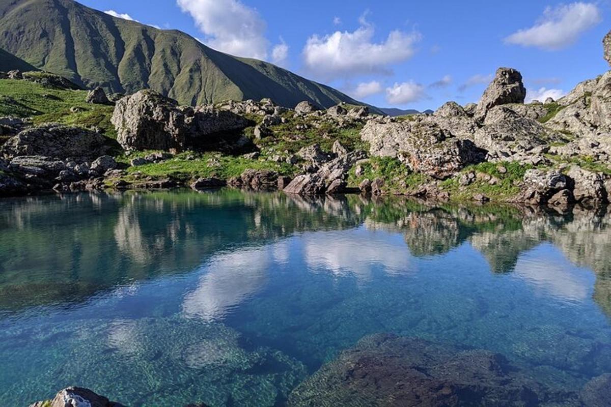 uno specchio d'acqua con una montagna sullo sfondo