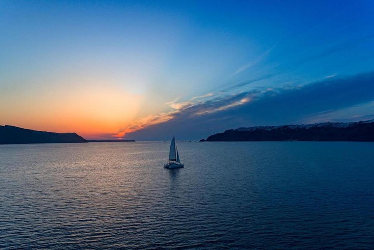 una barca a vela in mezzo a un grande specchio d'acqua