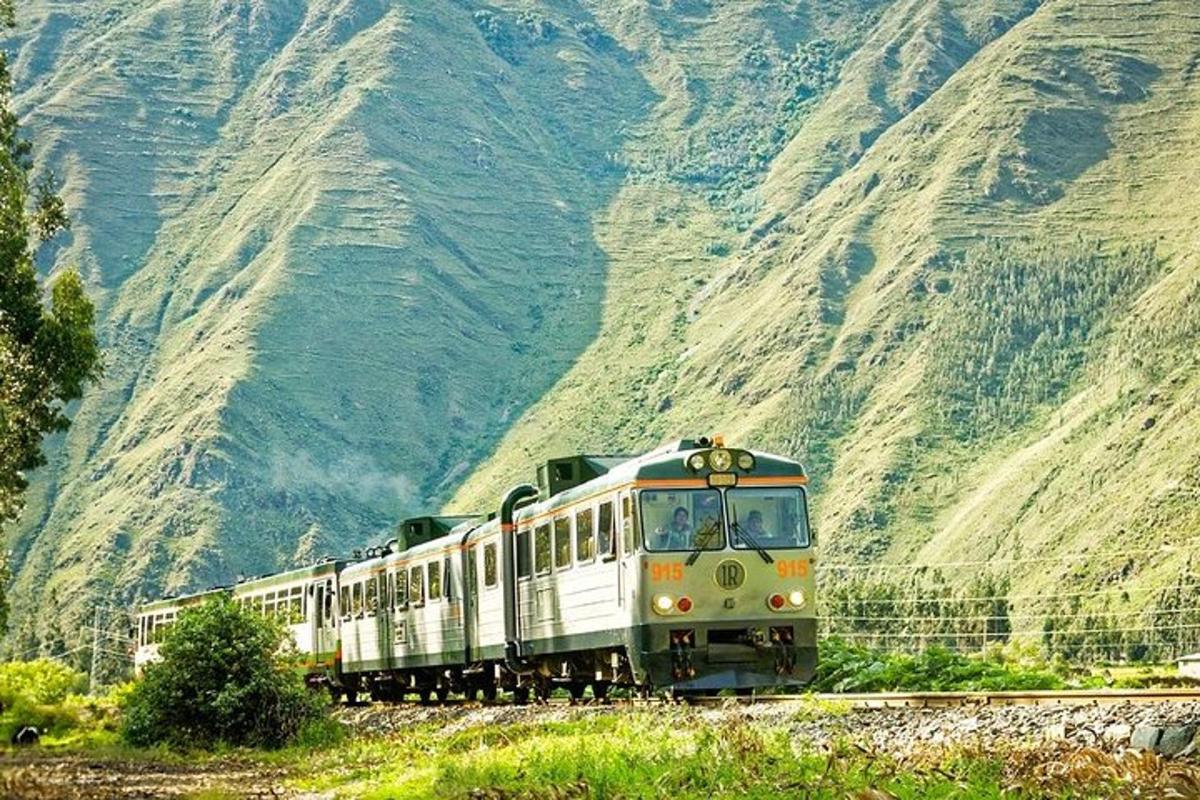Un tren que viaja por las vías cerca de una montaña.