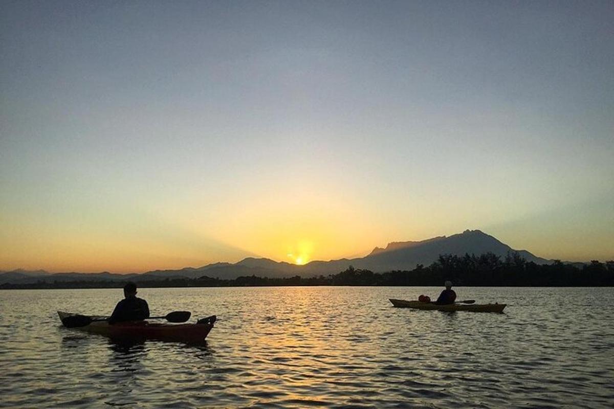 dua orang dalam sampan di tasik pada waktu matahari terbenam