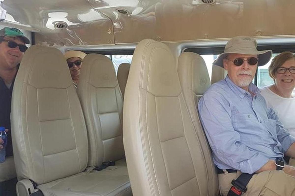 tiga orang duduk di belakang kereta