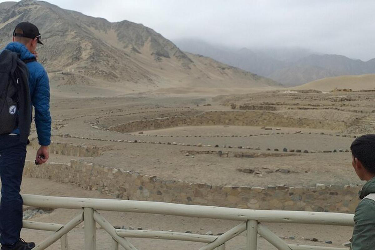 due uomini in piedi su una staccionata che guardano il deserto