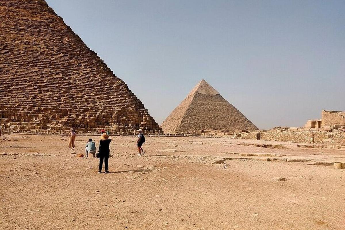 skupina ľudí stojaca pred pyramídami