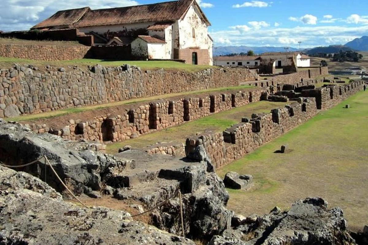 un vecchio muro di pietra con un edificio sullo sfondo