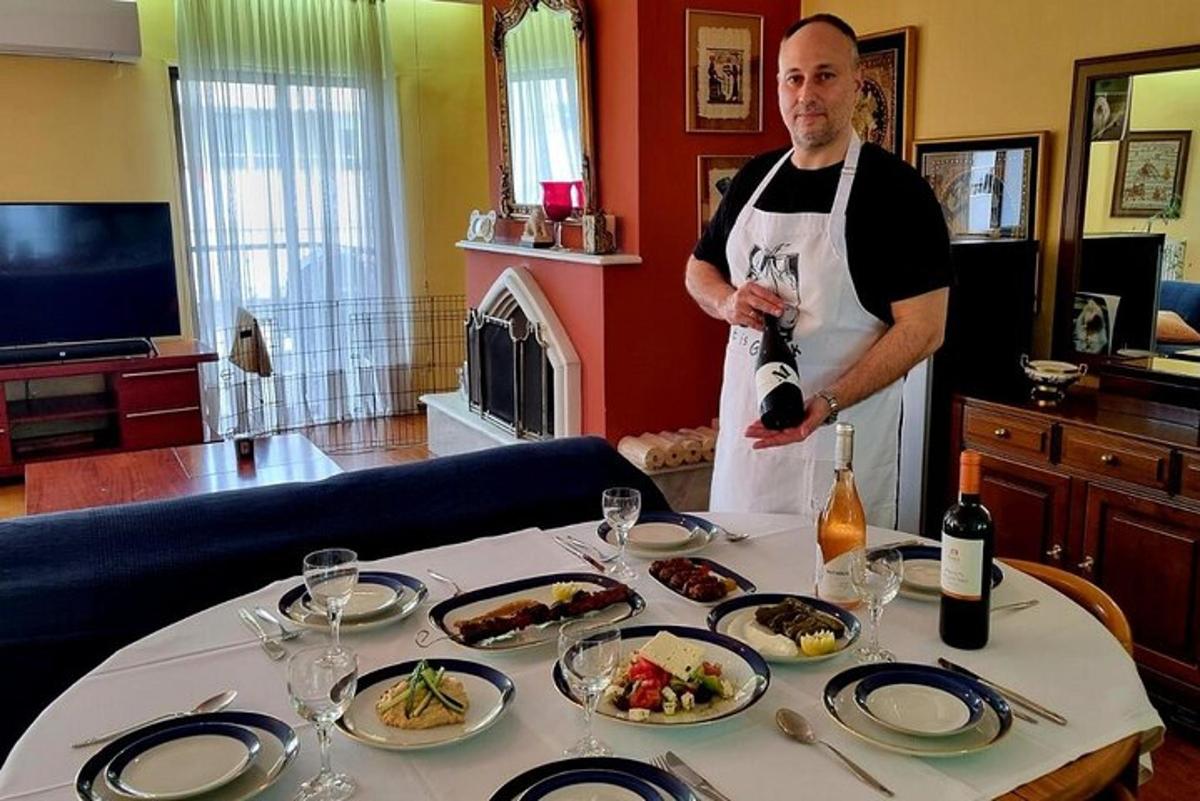 muž v zástěře stojící vedle stolu s jídlem