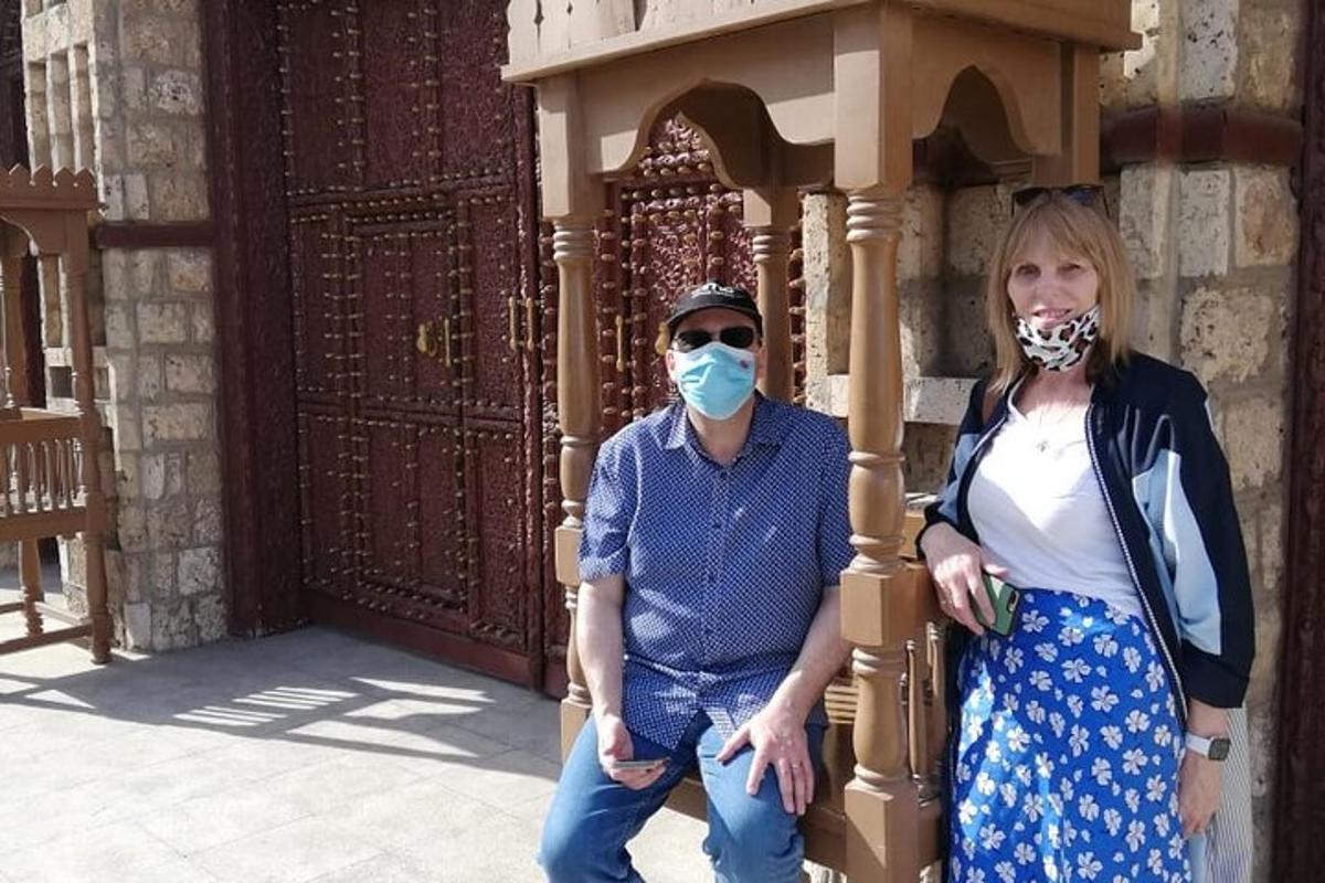 a man and a woman wearing masks in front of a building