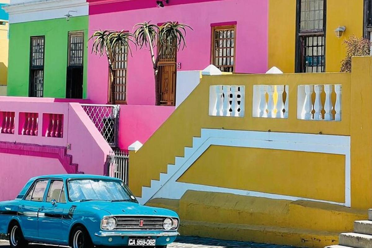 un cotxe blau aparcat davant d'un edifici de colors