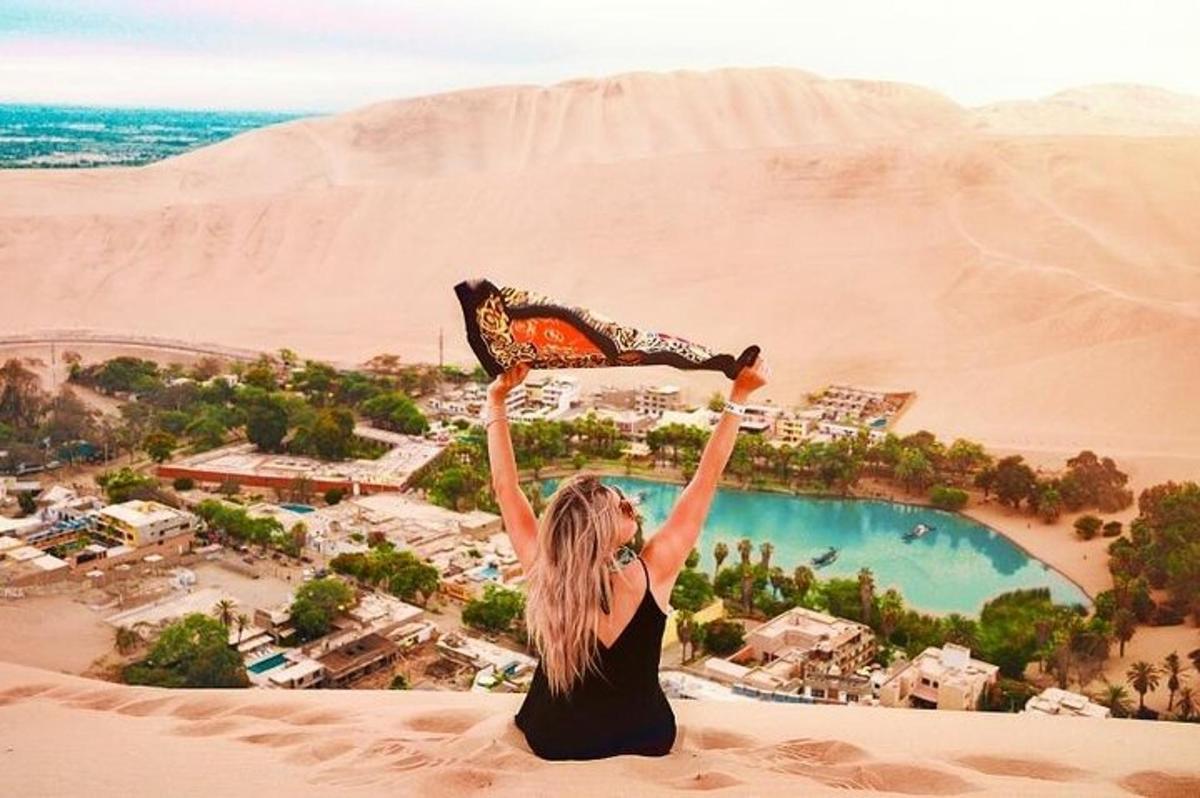 uma mulher sentada no deserto com os sapatos no ar