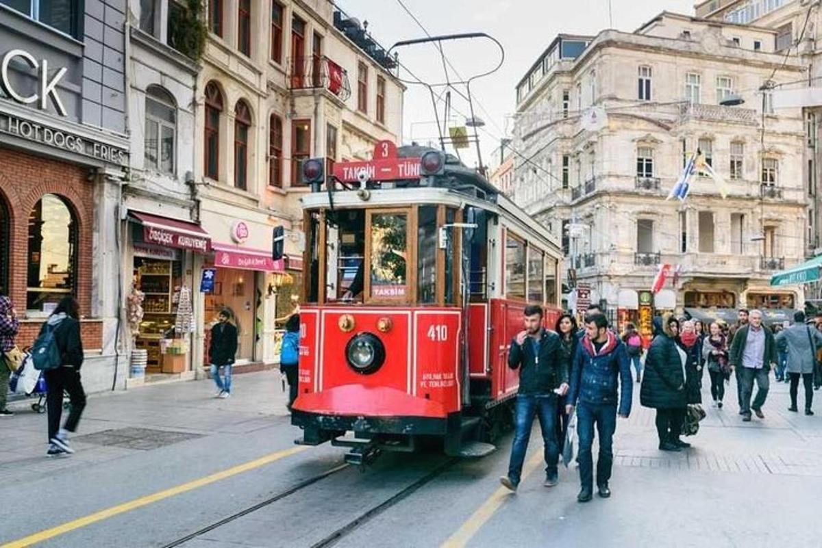 punainen raitiovaunu kaupungin kadulla ihmisten kanssa
