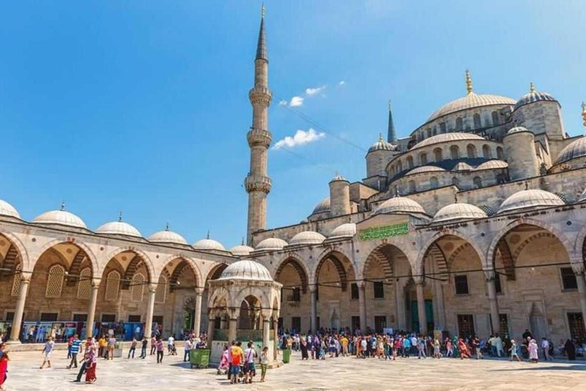 um grande edifício com uma mesquita com muitas pessoas