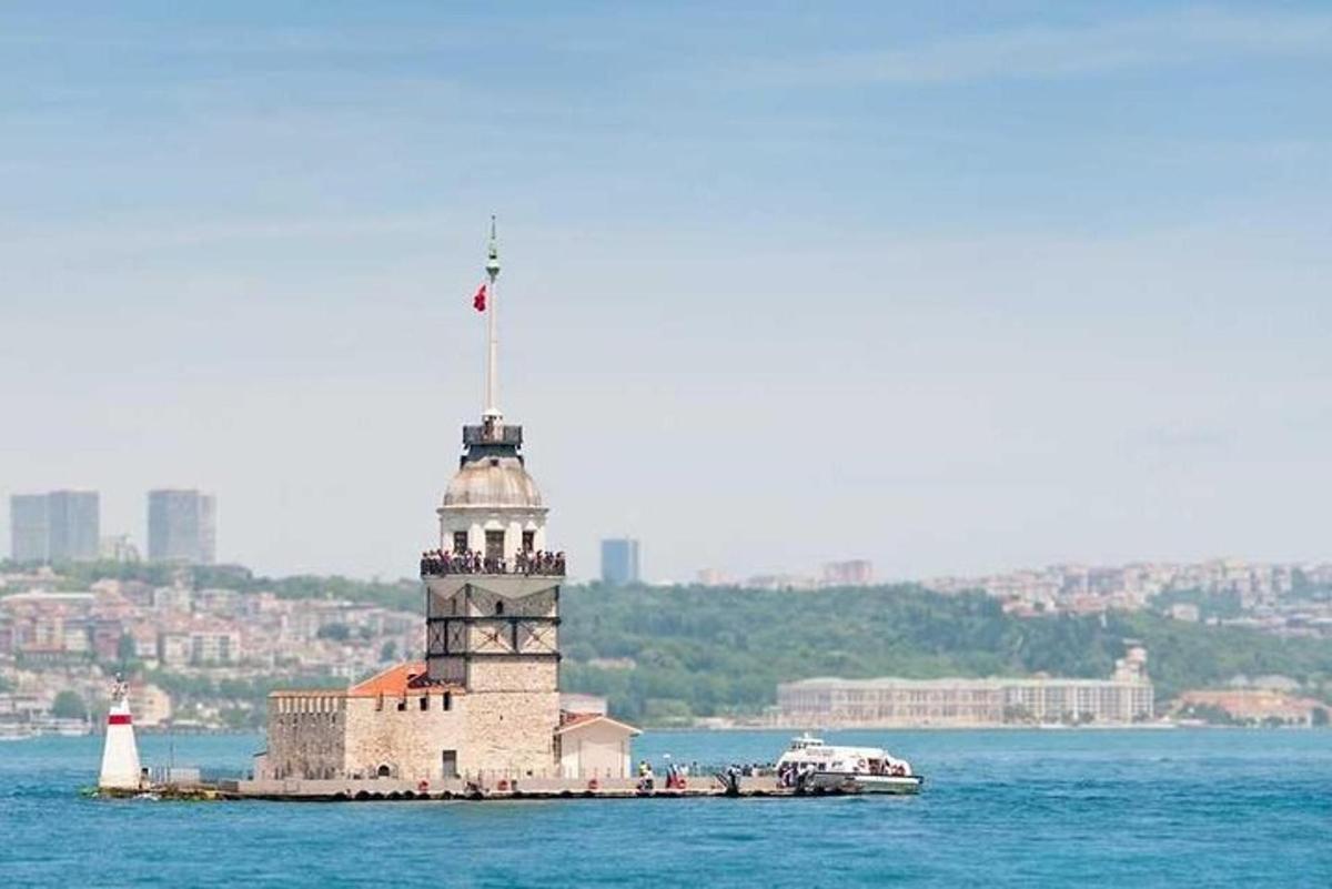 um farol no meio da água com um barco
