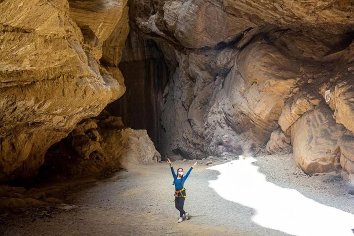 eine Frau, die mit erhobenen Armen in einer Höhle steht