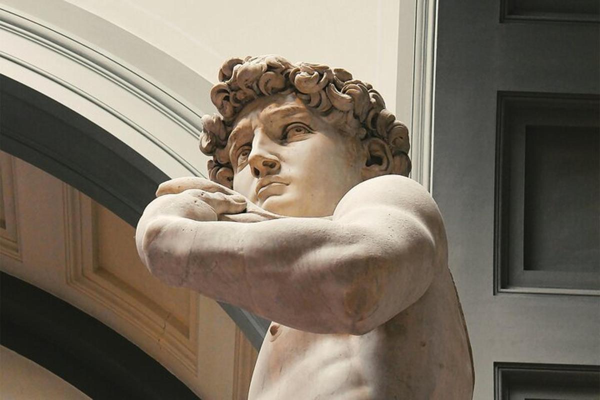 una statua di una donna in piedi accanto a un muro