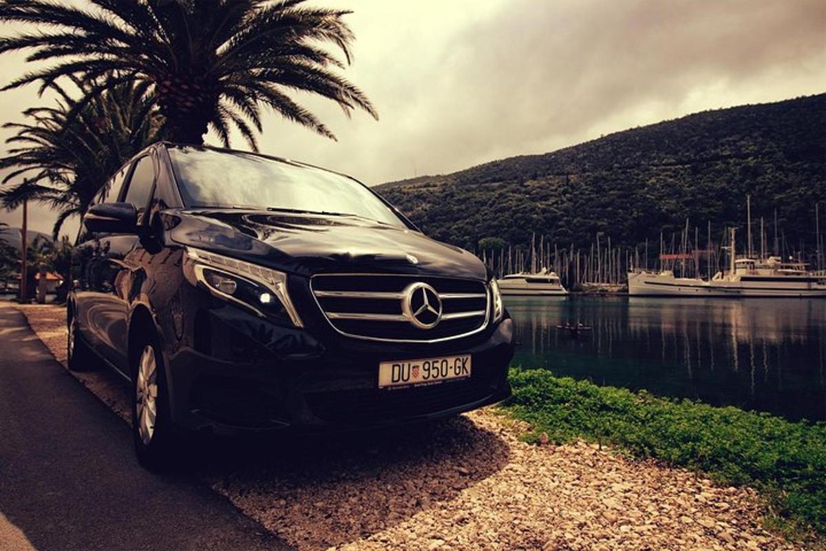 a black car parked next to a body of water