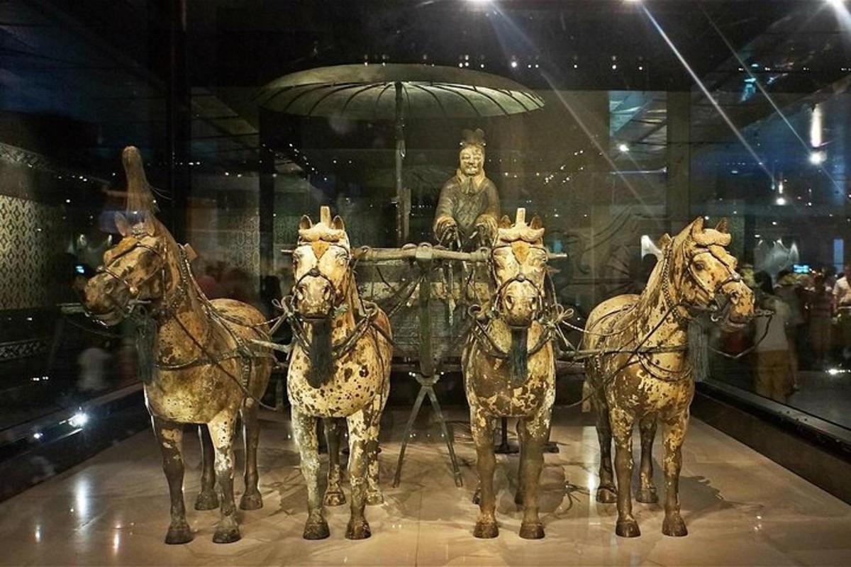 un gruppo di cavalli che trainano un carro con una statua