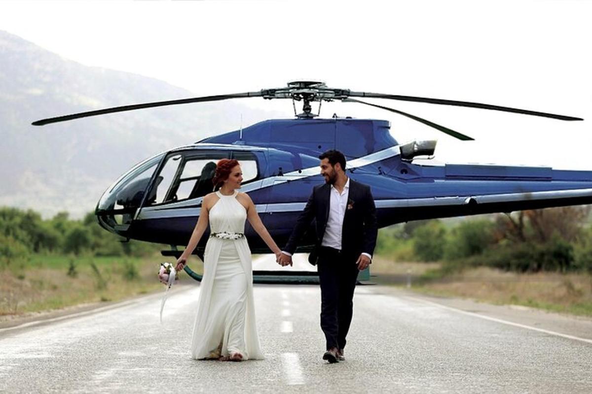 una sposa e uno sposo che camminano davanti a un elicottero