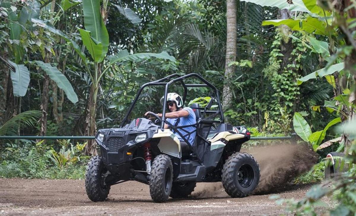 un home conduint un quad per un camí de terra