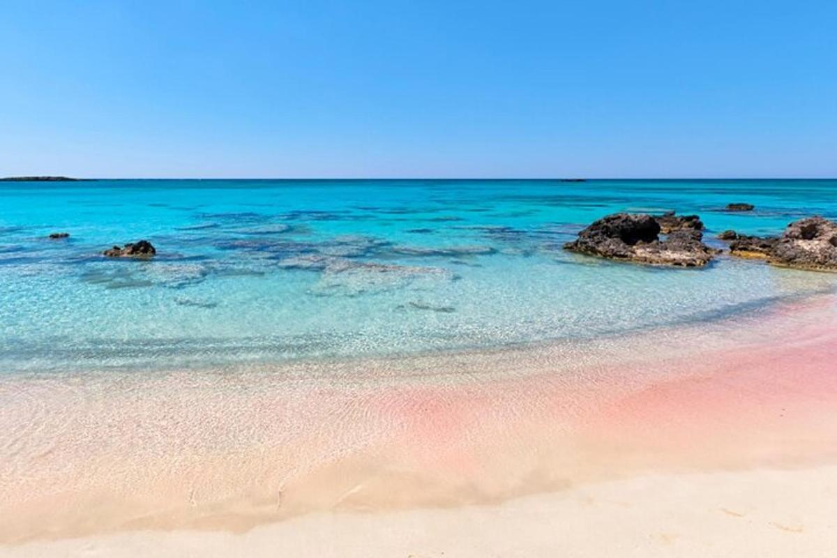 a beach with pink sand and blue water