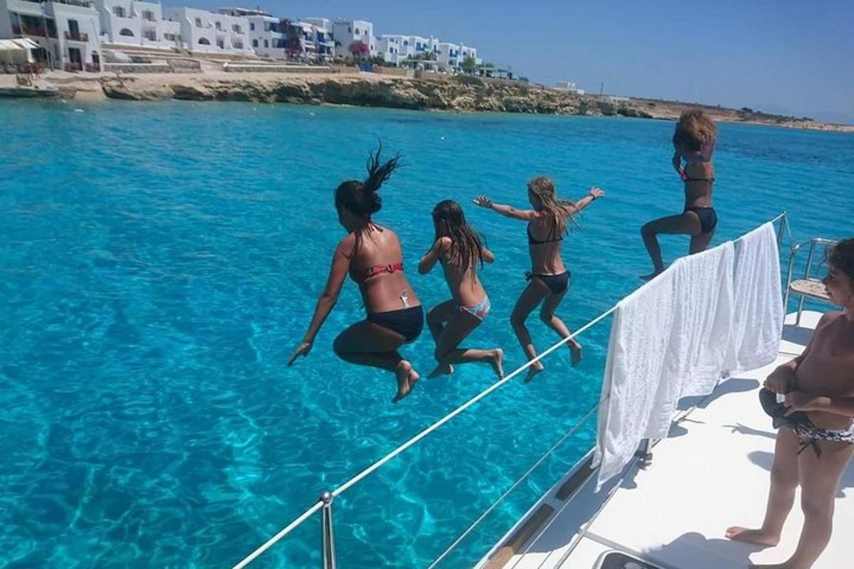 a group of women jumping off a boat in the water