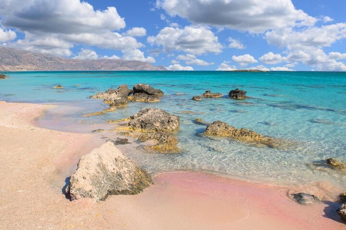 a beach with rocks in the water on a sunny day