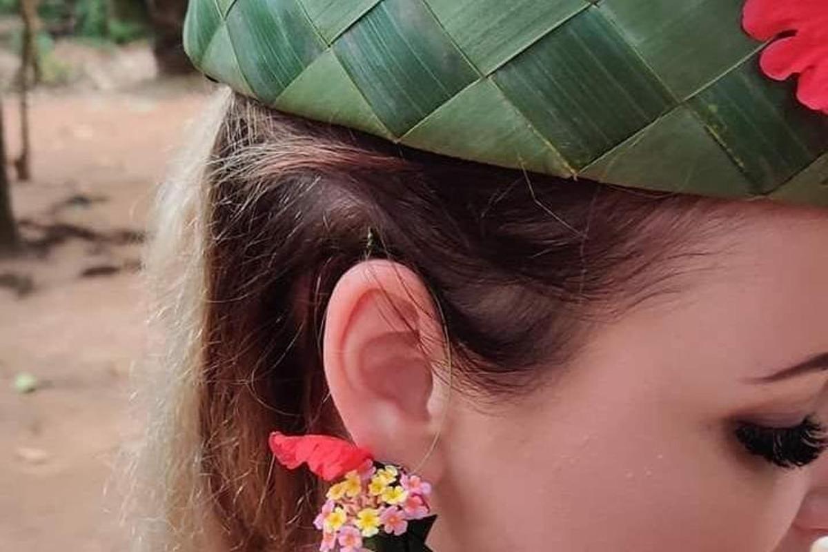 髪に花をつけた緑の帽子をかぶった女の子