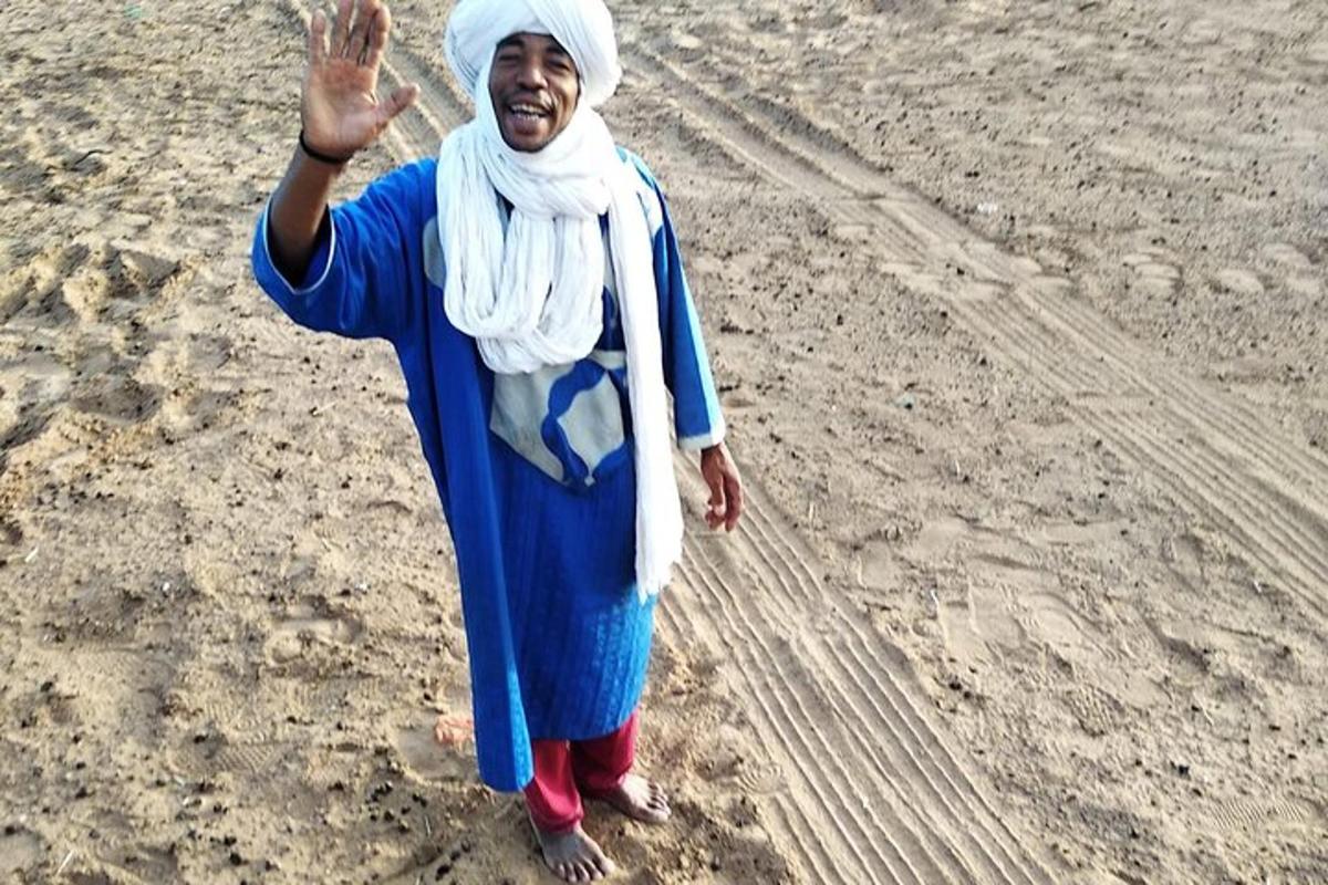 امرأة تقف على الشاطئ ويدها مرفوعة في الهواء
