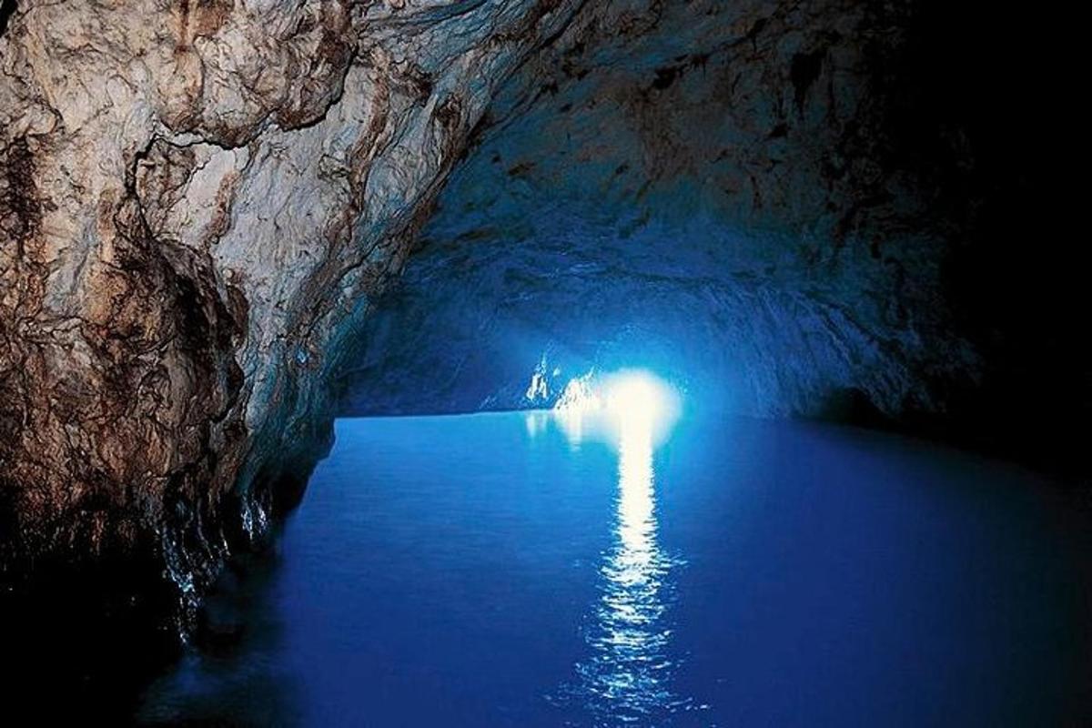 eine dunkle Höhle mit blauem Wasser darin