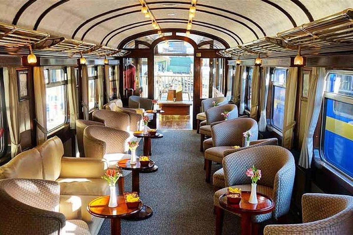 ein Zugwaggon mit Stühlen und Tischen in einem Raum