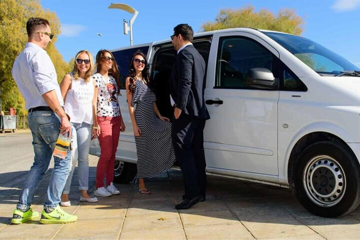 група људи стоји поред белог комбија
