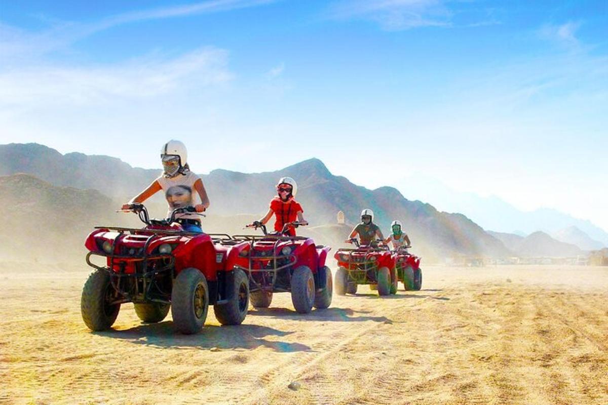 um grupo de pessoas andando de quadriciclo no deserto