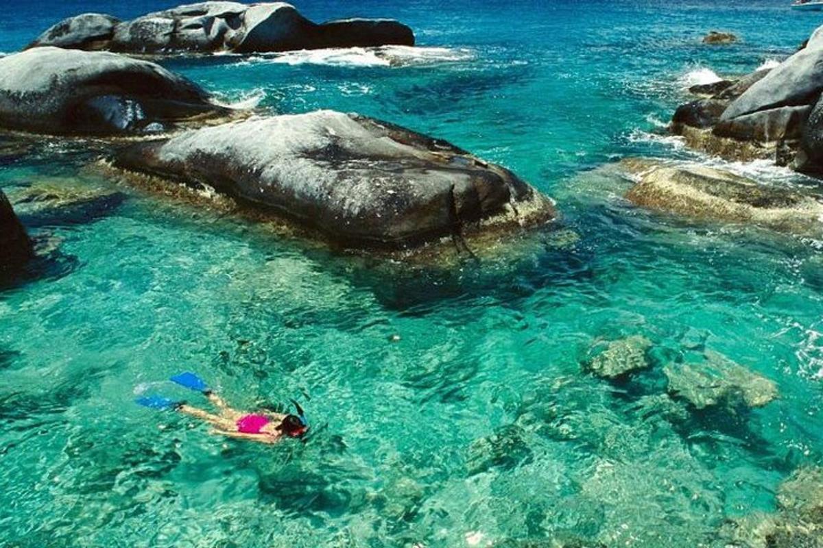 una persona nadando en el agua cerca de unas rocas