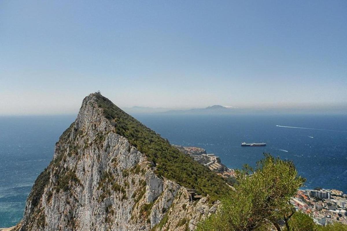 a mountain with a view of the ocean and a boat