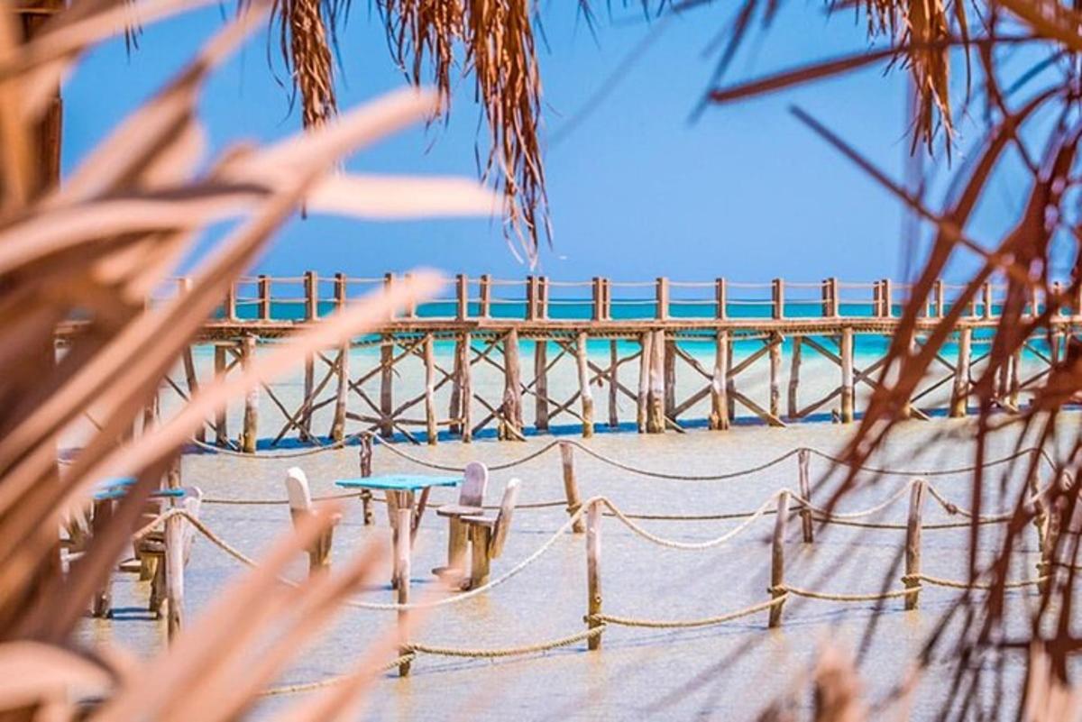 una spiaggia con sedie, un tavolo e un molo