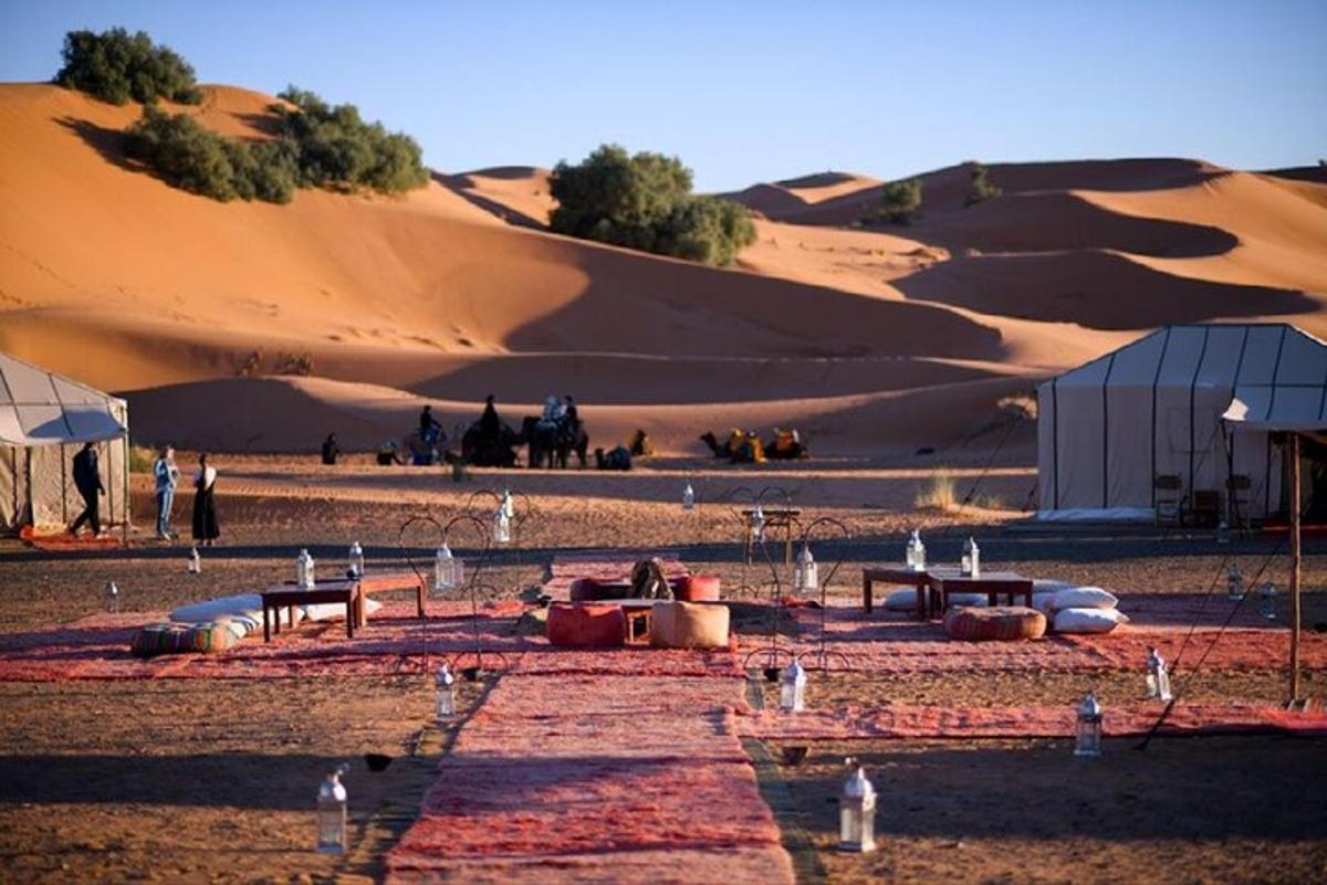 a group of people in a desert with sand dunes