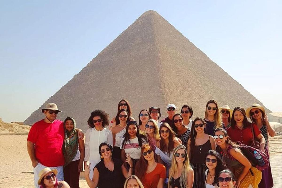 skupina lidí stojící před pyramidou