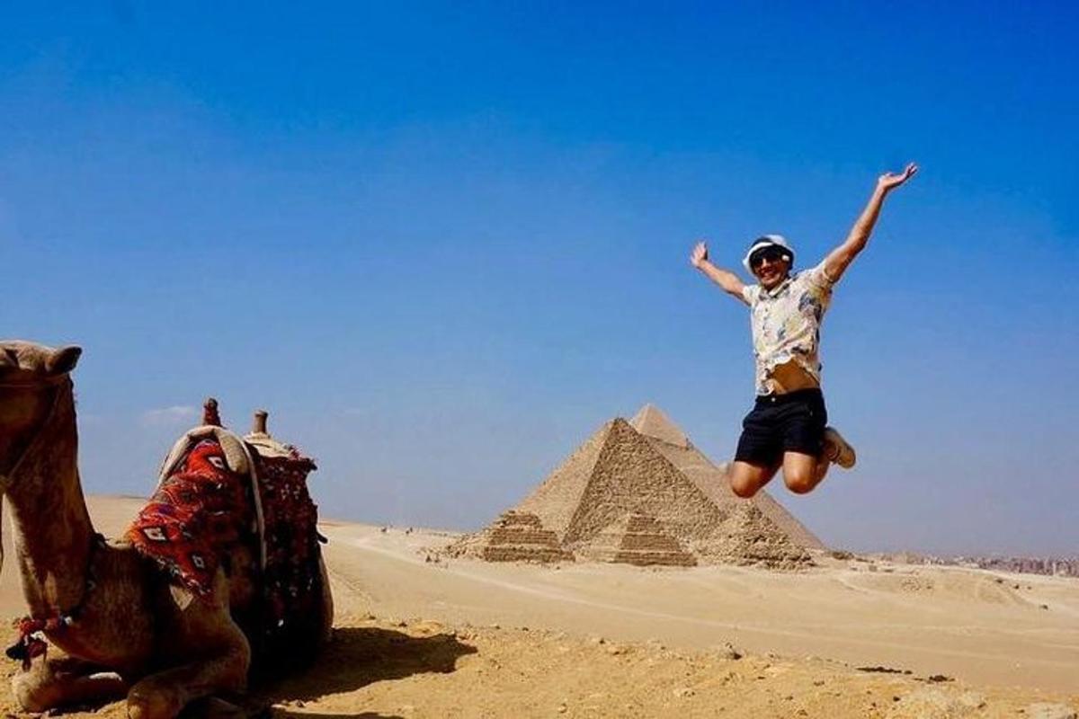 un uomo che salta in aria davanti alle piramidi